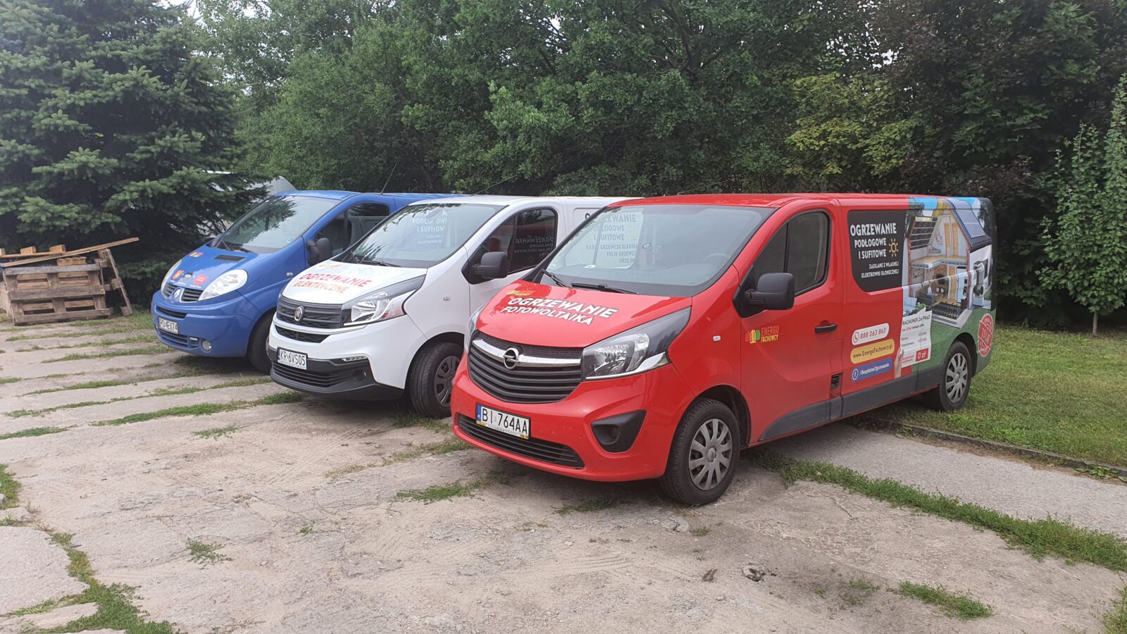 Oznakowane busy firmy ustawione w rzędzie przed wyjazdem na montaże