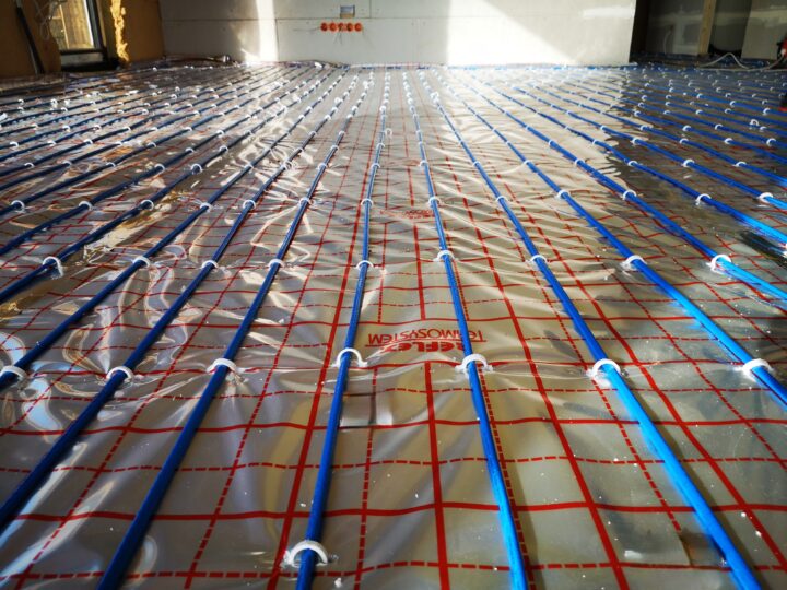Zbliżenie kabli grzewczych przypiętych do siatki na aluminiowej folii refleksyjnej